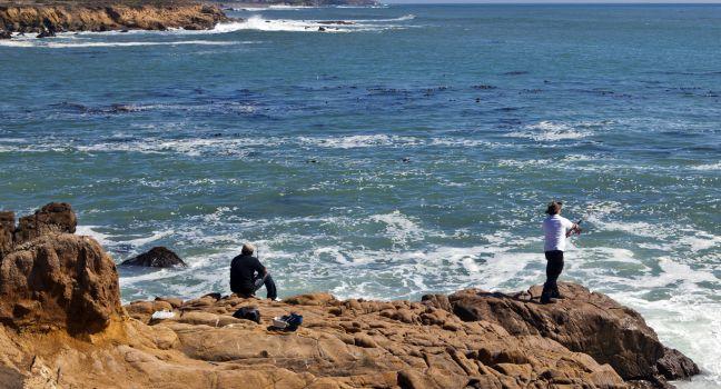 Anglers cast their lines into the turbulent waters off a rocky point on Moonstone Beach in Cambria, California.; 