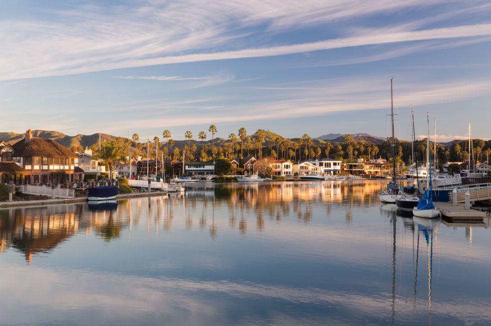 Sunrise at residential development by water in Ventura California with modern homes and yachts boats