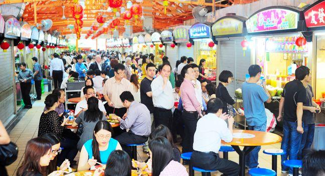 Singapore, Republic of Singapore - March 06, 2013: Locals eat at a popular food hall in Singapore. Inexpensive food stalls are numerous in the city so most Singaporeans dine out at least once a day.