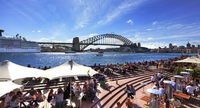 SYDNEY AUSTRALIA - SEPTEMBER 15, 2013: Residents and visitors dine, relax and basque in the glorious afternoon sun quayside by the harbour, Sydney Australia.  ;