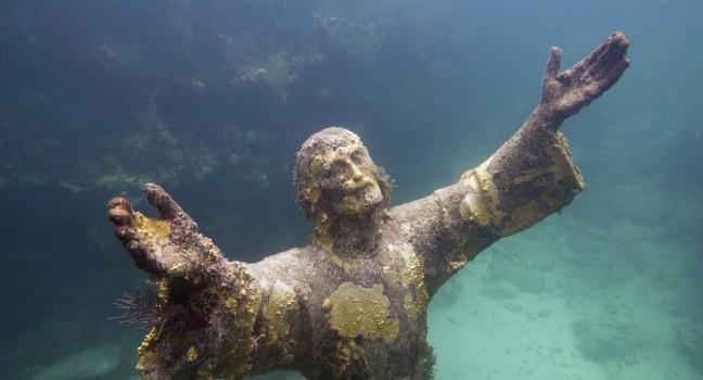 Christ of the abyss - religious underwater statue encrusted in corals, placed about 25 feet deep in John Pennekamp Coral Reef State Park in Florida Keys. Replica of the Italian sculpture. Wide angle, side flash and sunlight combined.