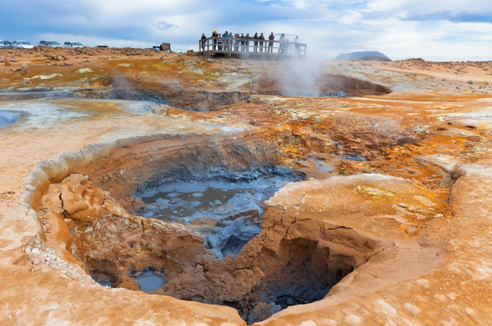 Tourists Looking The Hot Mud Pots in the Geothermal Area Hverir, Iceland.