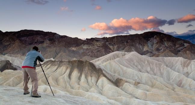 Landscape photographer taking pictures at sunrise in Death Valley national park in California.; 
