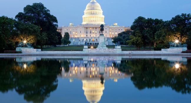 The United States Capitol building in Washington DC, USA - after dark with water reflection.