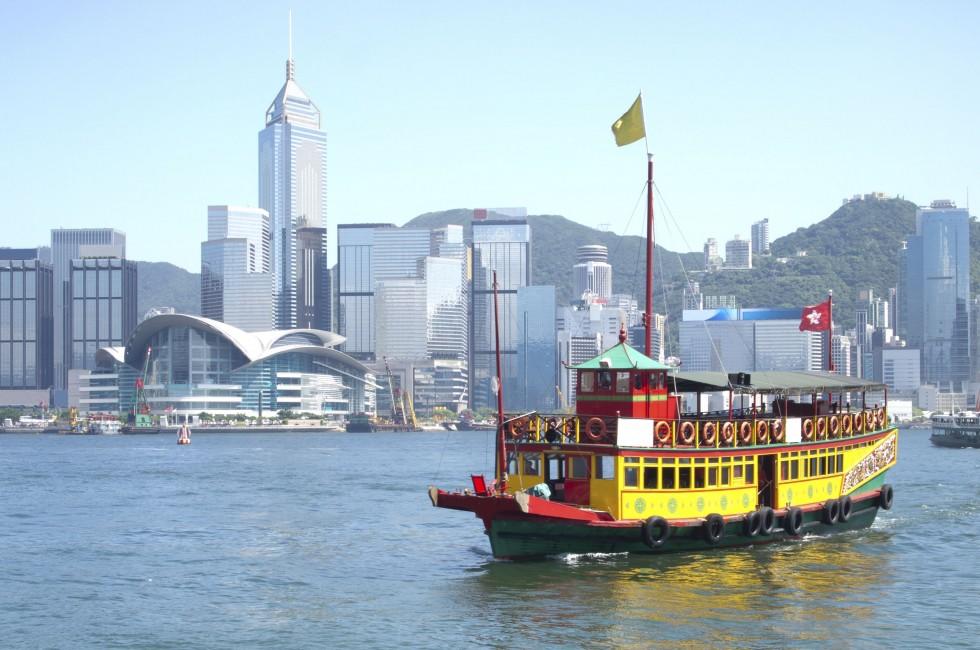 Landmark of Hong Kong buildings and tourists junk boat.