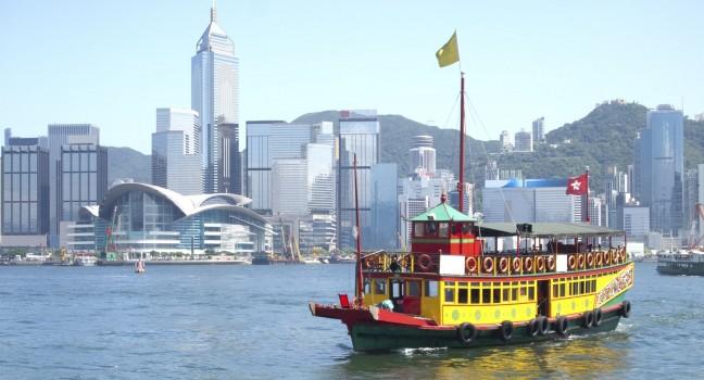 Landmark of Hong Kong buildings and tourists junk boat.