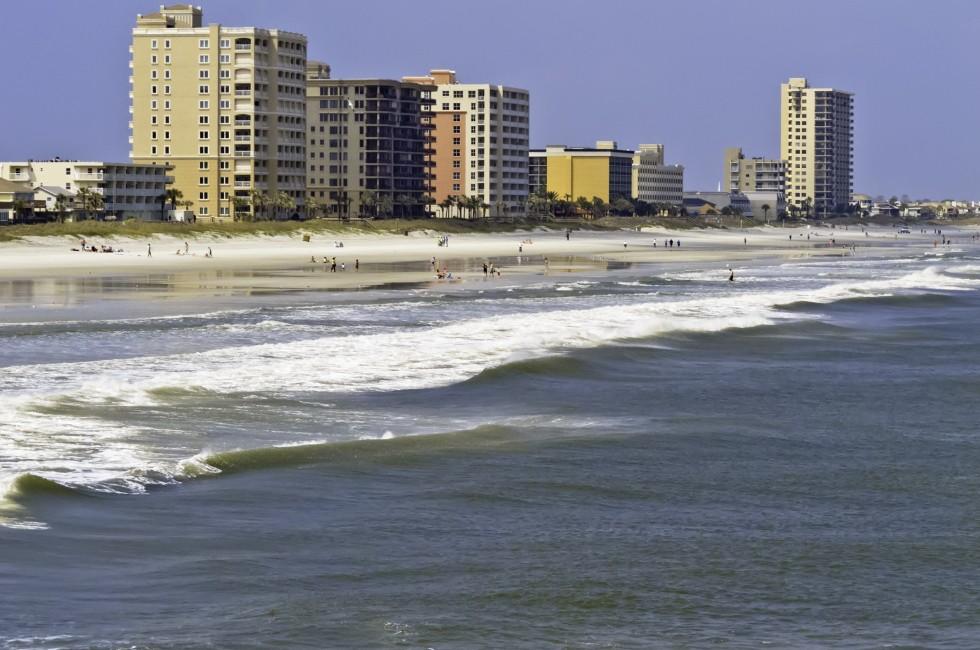 Vacation lifestyle: Surf, sand, and high-rise skyline along shore of Jacksonville Beach, Florida, on a sunny afternoon 