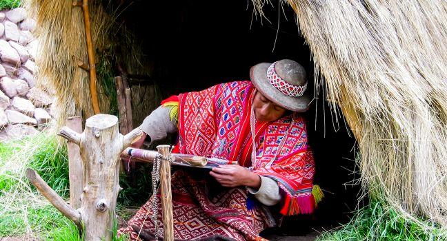 PISAC, PERU - MARCH 2, 2006: Unidentified woman at Awana Kancha Llama Farm at Cusco-Pisac highway in Peru. Awana Kancha is a center which preserves the local fabric arts: wool-making and weaving.