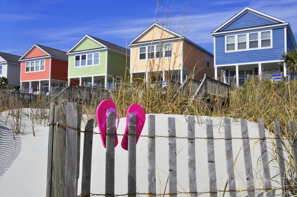 Row of beach rentals on a summer day, pink flip flops on beach fence;  Myrtle Beach, South Carolina