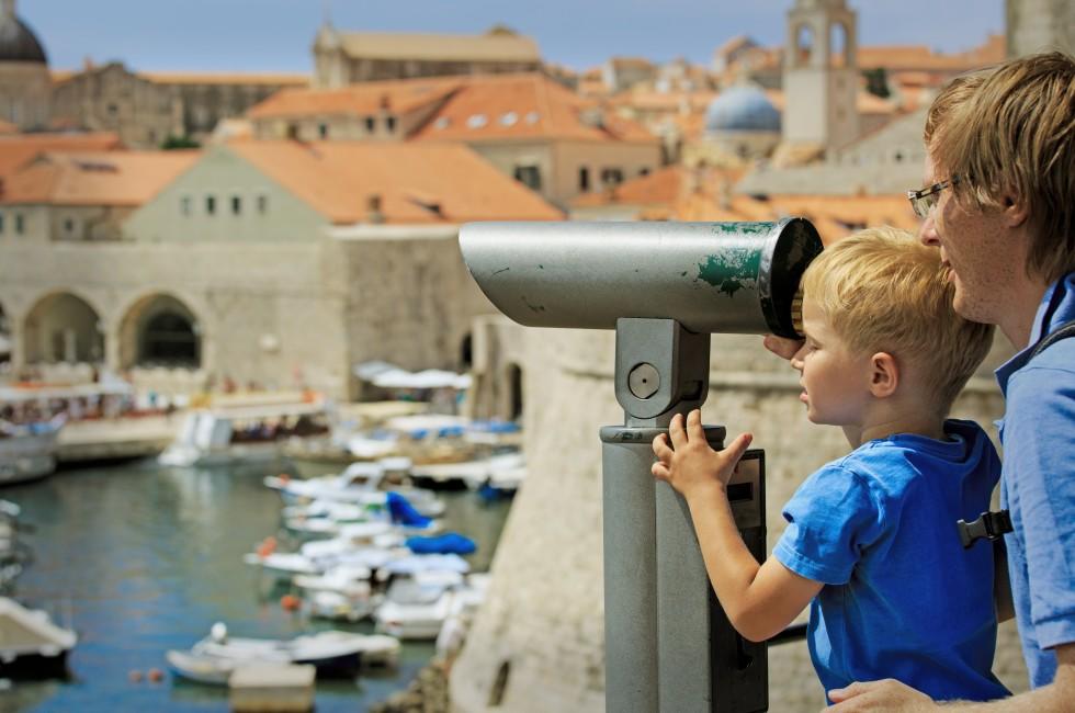 father and son looking through binoculars at the city of Dubrovnik