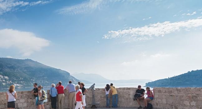 DUBROVNIK, CROATIA - OCTOBER 10, 2009: Tourists on old city walls which have been considered to be amongst the great fortification systems of the Middle Ages.
