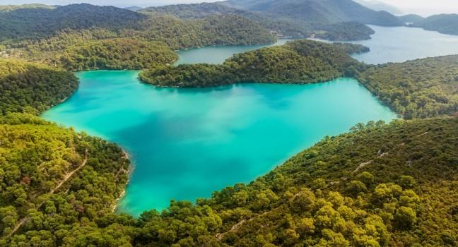Aerial helicopter shoot of National park on island Mljet, Dubrovnik archipelago, Croatia. The oldest pine forest in Europe preserved.; 