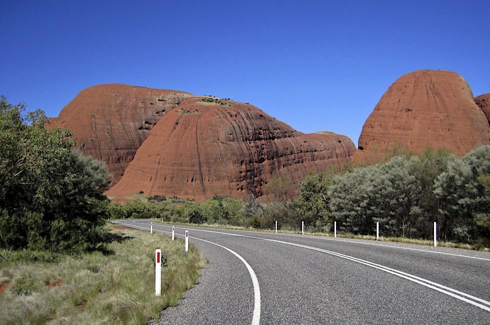 Australia, Road in the middle of Australia to Uluru with the view to orange hils and blue sky background, tourist route, popular place in Australia, Uluru 