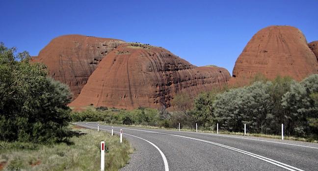 Australia, Road in the middle of Australia to Uluru with the view to orange hils and blue sky background, tourist route, popular place in Australia, Uluru 