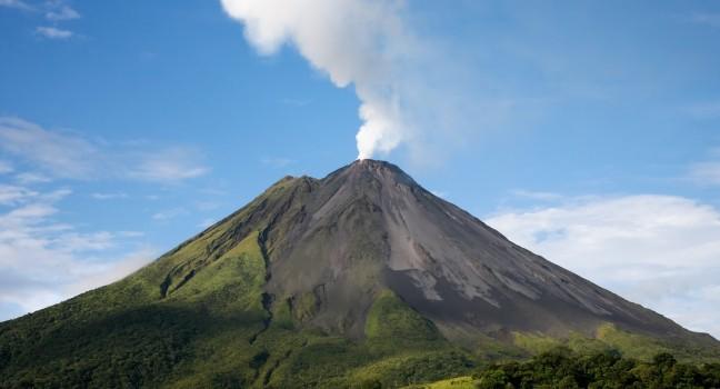 Arenal volcano in costa rica with a plume of smoke.