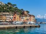 Pier and boats on bockground of colorful houses in bay of Portofino, Italy.; 