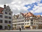 View to the facades and roofs of old houses at the market place of Torgau (Saxony; Germany). The market place is located in the old town with a lot of Patrician and Renaissance style houses. People go shopping or there are visiting the town. In the buildin