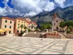 Traditional buildings and church on a sunny square from the old town of Makarska, Croatia