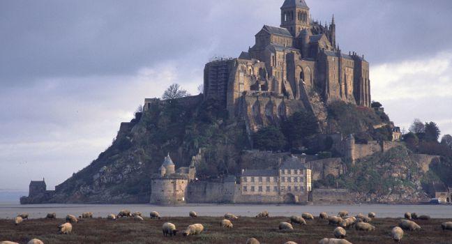 A solitary shepherd's cane is his biggest ally out on the marshes beneath the 13th century island abbey, where deadly quicksand and racing tides can be vocational hazards, Mont St. Michel: France