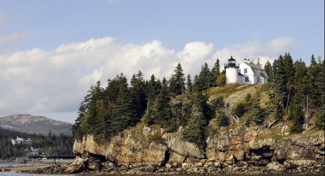A scenic view of a Bar Harbor, Maine lighthouse on a beautiful autumn day. Taken from the water.  Focus on the lighthouse.