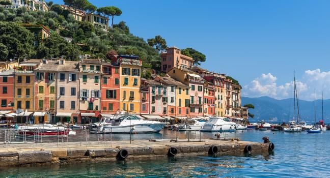 Pier and boats on bockground of colorful houses in bay of Portofino, Italy.; 