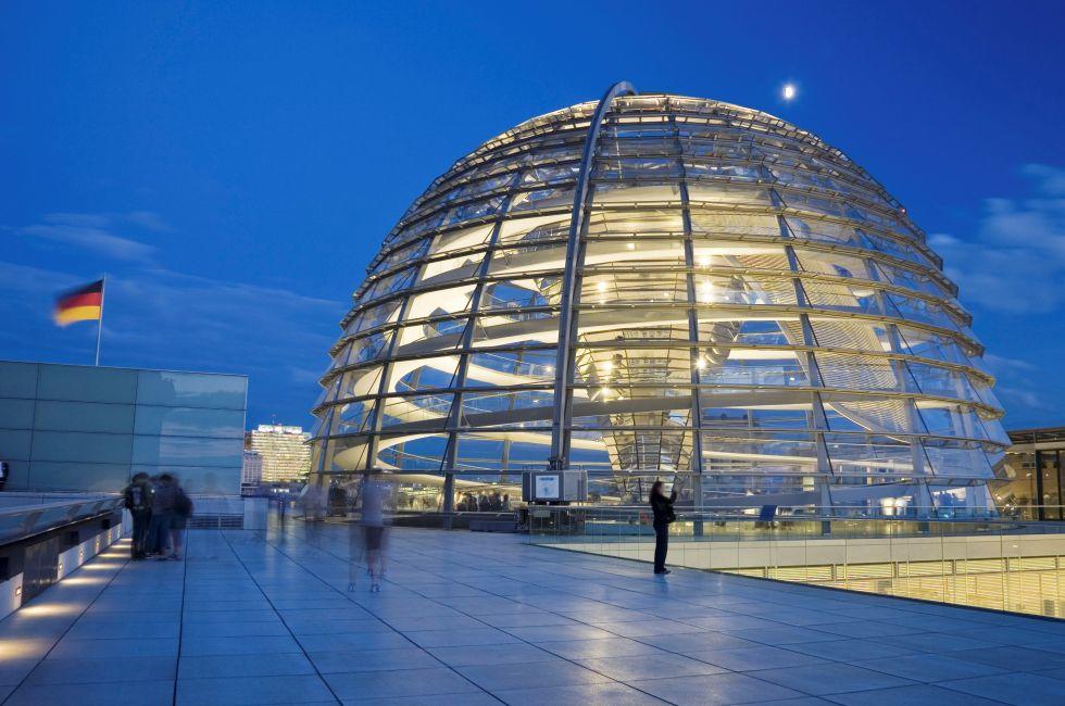 Illuminated glass dome on the roof of the Reichstag in Berlin in the evening; 