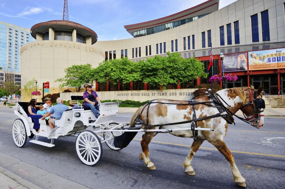 NASHVILLE - JUNE 14:A horse-drawn carriage passes the Country Music Hall of Fame and Museum June 14, 2013 in Nashville, TN. The museum opened in 1961 and preserves the history of country music.