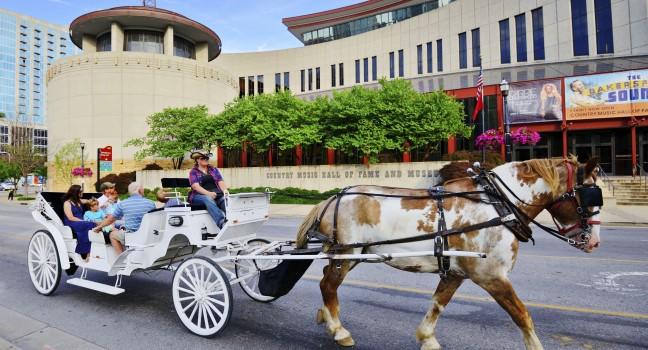 NASHVILLE - JUNE 14:A horse-drawn carriage passes the Country Music Hall of Fame and Museum June 14, 2013 in Nashville, TN. The museum opened in 1961 and preserves the history of country music.