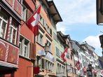 Old street in Zurich decorated with flags for the Swiss National Day, 1st of August; 