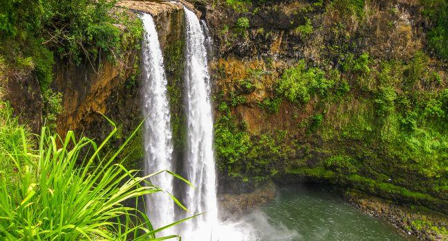 Aerial view of tropical Manawaiopuna Falls also called Jurassic Park Falls in Kauai, Hawaii, USA. .