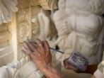 Stone mason at work carving an ornamental relief.