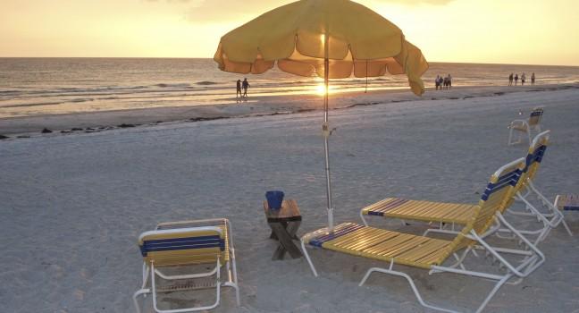 Beach chairs and umbrellas at sunset, Clearwater, Florida.;