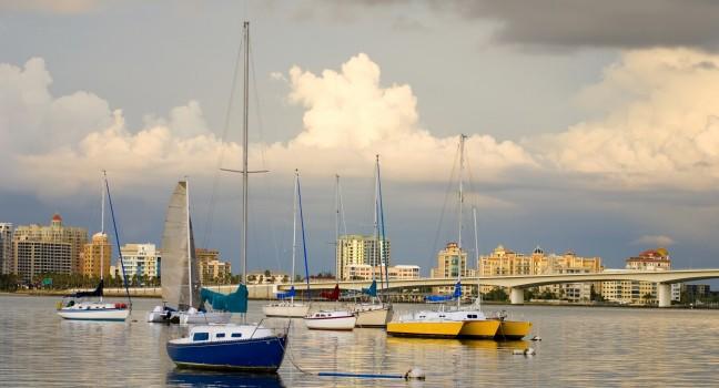 Boats anchored in a harbor under cloudy skies; 