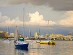 Boats anchored in a harbor under cloudy skies; 