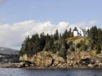 A scenic view of a Bar Harbor, Maine lighthouse on a beautiful autumn day. Taken from the water.  Focus on the lighthouse.