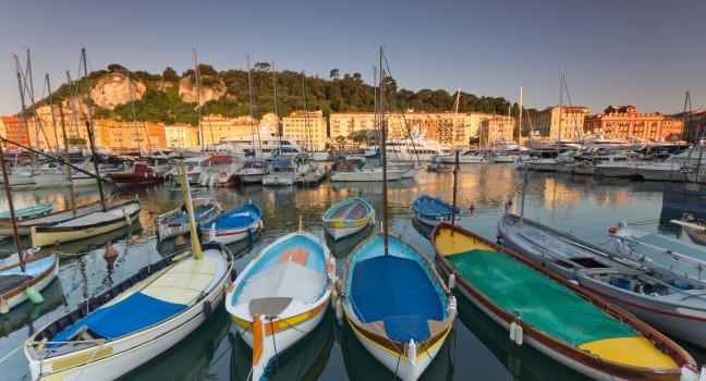 Old classic wooden boats and luxury yachts rest in the old port of Nice , cote azur, France.