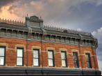 upper sandstone facade  of Miller Block (1888) at historic downtown of Fort Collins, Colorado against cloudy sky at sunset