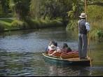 CHRISTCHURCH, NEW ZEALAND - MARCH 31, 2013: A boatman guides a group of tourists in their punt down the Avon River on Easter Sunday afternoon on March 31, 2013 in Christchurch.