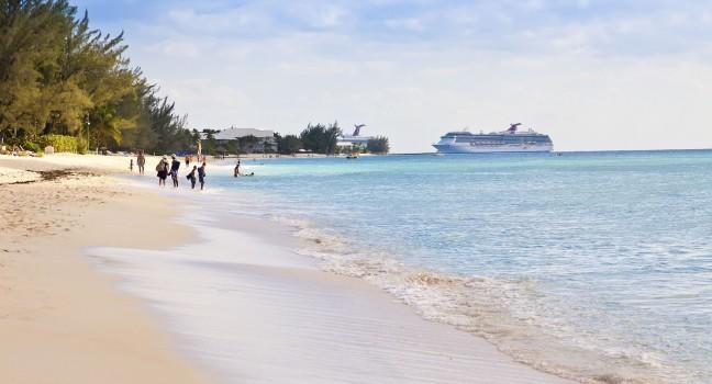 GRAND CAYMAN, CAYMAN ISLANDS - MAR.8:  Tourists enjoying Seven Mile Beach in Grand Cayman on Mar. 8, 2013.  The beach is a local tourist attraction, offering many luxury resorts and water sports.;