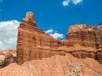 Chimney Rock, a red cliff of sandstone is backed by a deep blue sky in the Utah desert of Capitol Reef National Park.