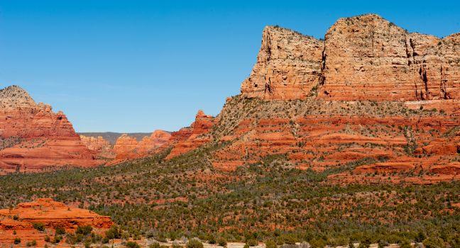 A wide shot of the beautiful Sedona mountains and bluffs under a cloudless sky in Arizona