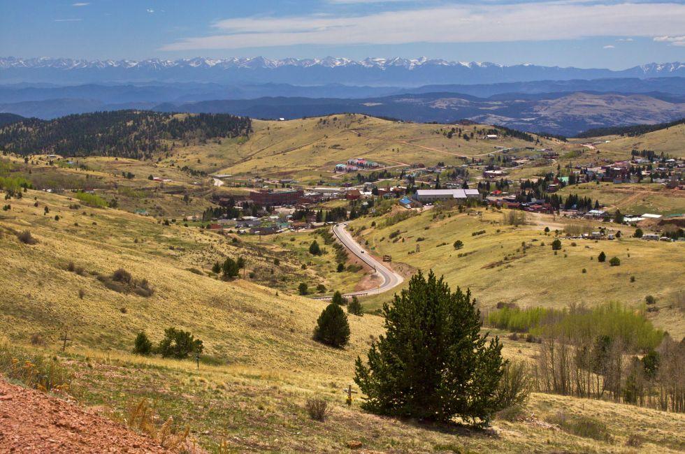 An overlook along a highway looking down into the small gambling town of Cripple Creek, Colorado. Once the hotbed of the gold mining era it is now a casino town. The Sangre De Cristo Mountains are visible in the distance.