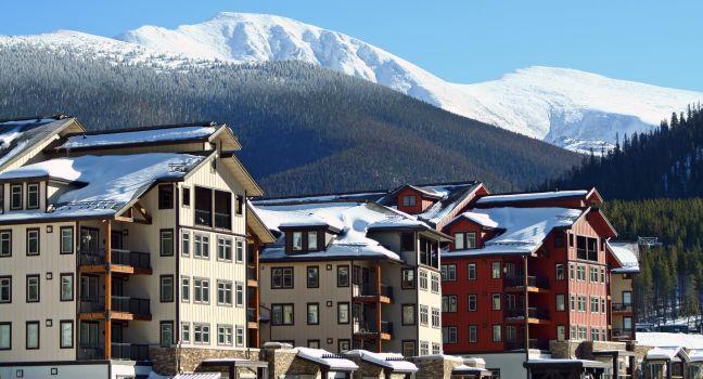 Ski lodges at Winter Park, Colorado with a view of the Rocky Mountains in the background.