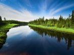 The river with a quiet current and clouds reflected in it, Russia, Yakutia.