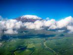 Aerial image of Mount Kilimanjaro, Africa's highest mountain, with snow and white puffy clouds from Kenya