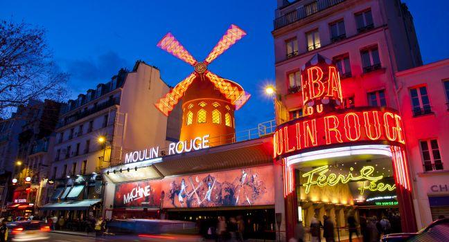 The Moulin Rouge by night, on March 3, 2010 in Paris, France. Moulin Rouge is a famous cabaret built in 1889 and is located in the Paris red-light district of Pigalle.