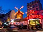 The Moulin Rouge by night, on March 3, 2010 in Paris, France. Moulin Rouge is a famous cabaret built in 1889 and is located in the Paris red-light district of Pigalle.