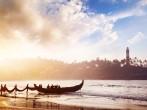 Indian fishermen in silhouette with fishing nets near the boat on the beach in the morning at lighthouse background in Kovalam, Kerala, India.