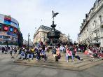 People enjoying the sun at Piccadilly Circus London.