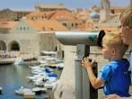 father and son looking through binoculars at the city of Dubrovnik